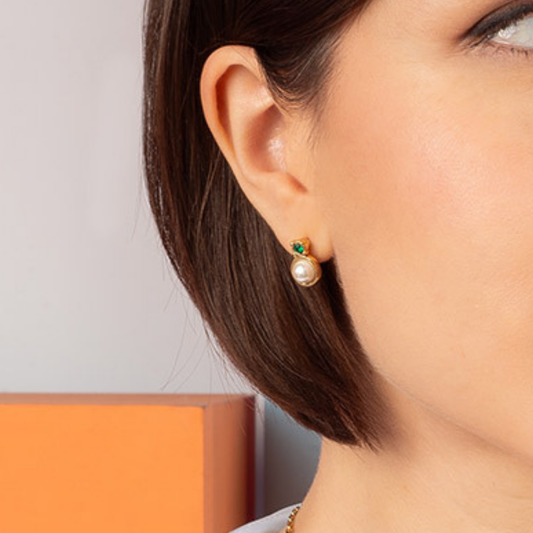 Aretes con perla tono crema y piedra en tono verde